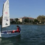 A young person sailing in a small boat on the waters of İstanbul, enjoying a sunny day.