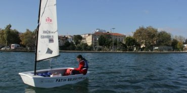 A young person sailing in a small boat on the waters of İstanbul, enjoying a sunny day.