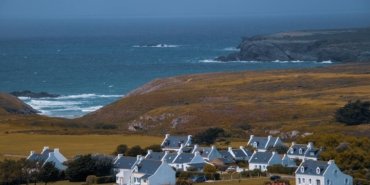 A serene view of a picturesque village along the Brittany coast in France, overlooking the sea.
